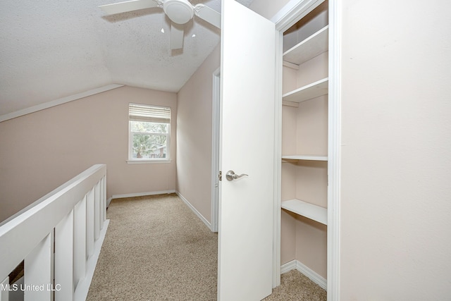 walk in closet with ceiling fan, light carpet, and lofted ceiling