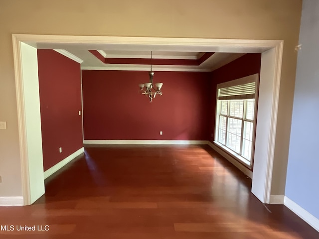 unfurnished dining area with crown molding, wood finished floors, a raised ceiling, a chandelier, and baseboards