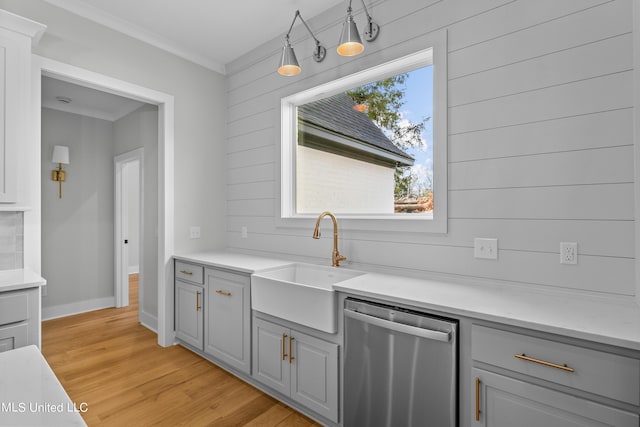 kitchen with a sink, light wood-type flooring, gray cabinets, dishwasher, and crown molding