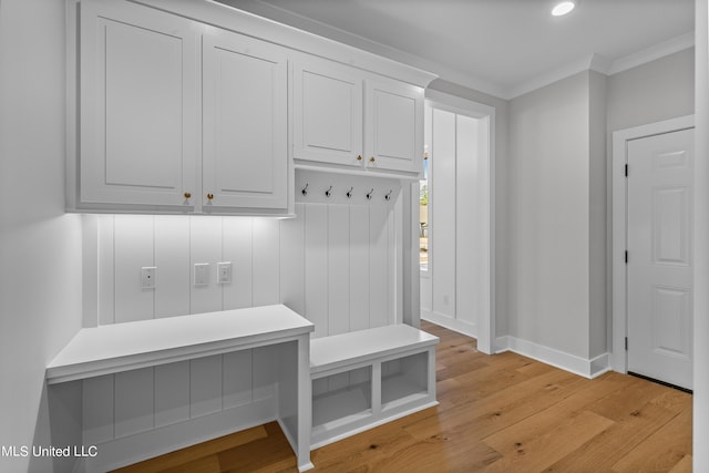 mudroom featuring light wood-style floors, ornamental molding, and baseboards