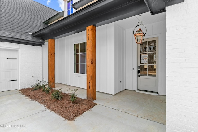 entrance to property featuring brick siding and roof with shingles