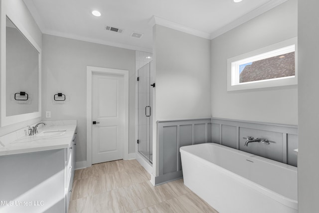 bathroom featuring ornamental molding, visible vents, a freestanding bath, and vanity