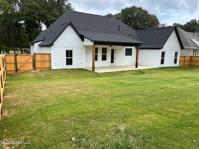 back of property featuring a yard, a patio, a shingled roof, a gate, and a fenced backyard