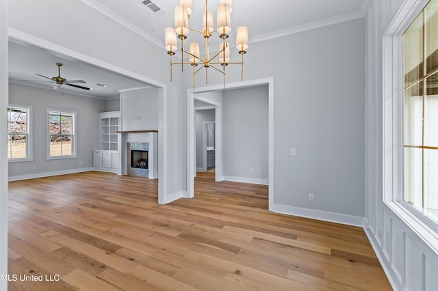 unfurnished living room featuring light wood-style floors, a fireplace, visible vents, and ornamental molding