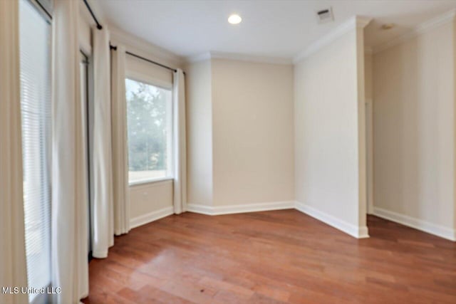 unfurnished room featuring hardwood / wood-style floors and ornamental molding