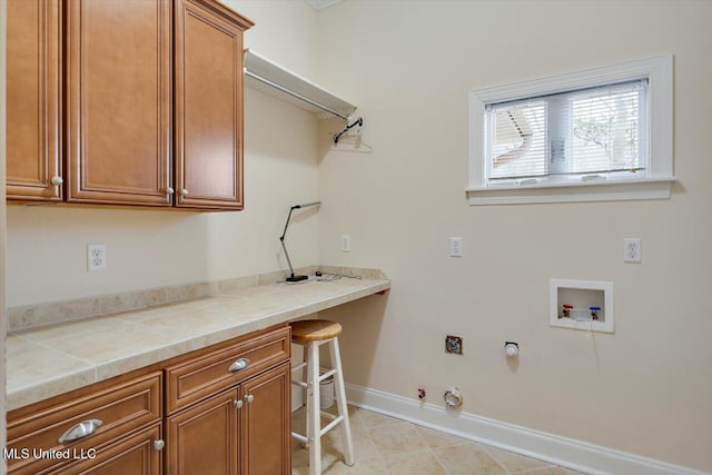 clothes washing area with hookup for a washing machine, cabinets, and hookup for a gas dryer