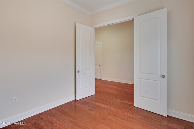 unfurnished room featuring crown molding and light wood-type flooring