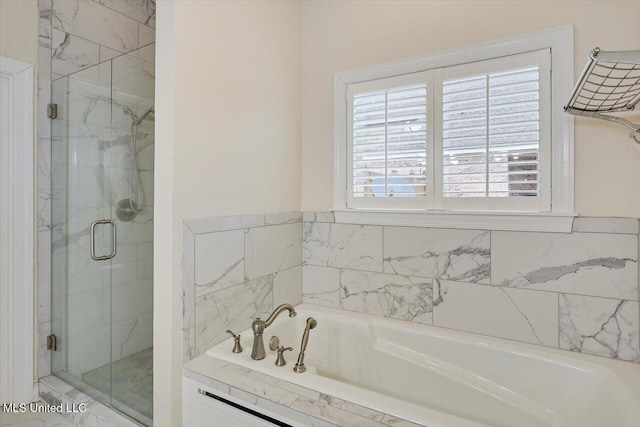 bathroom featuring shower with separate bathtub