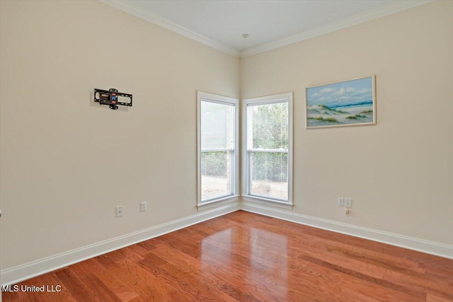 spare room with plenty of natural light, wood-type flooring, and crown molding