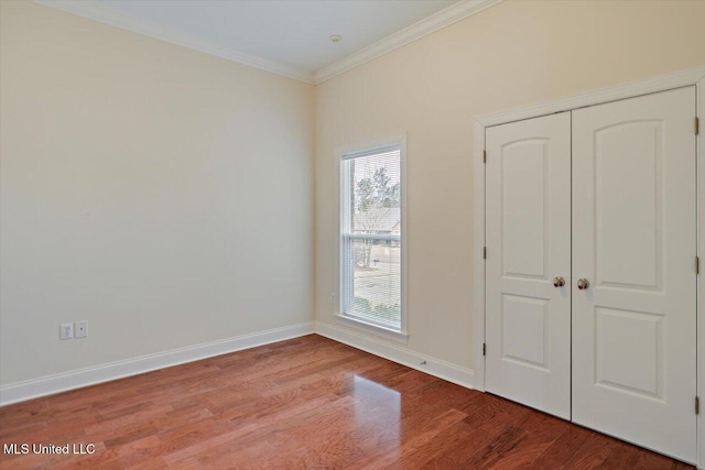 unfurnished bedroom featuring hardwood / wood-style flooring, a closet, and ornamental molding