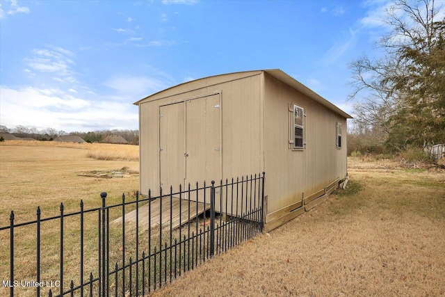 view of outbuilding with a lawn and a rural view