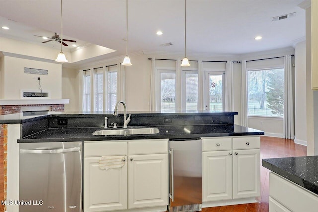 kitchen featuring white cabinetry, sink, a raised ceiling, ornamental molding, and stainless steel dishwasher