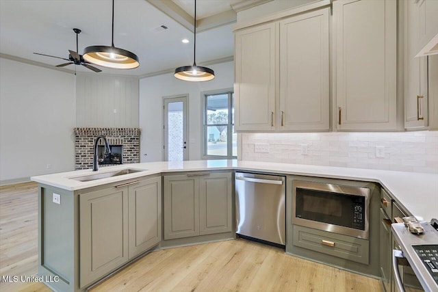 kitchen featuring sink, ornamental molding, built in microwave, decorative light fixtures, and stainless steel dishwasher