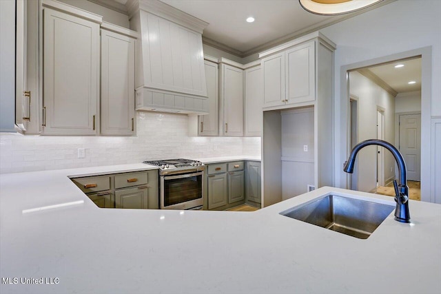 kitchen with tasteful backsplash, sink, custom exhaust hood, crown molding, and stainless steel gas range