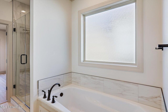 bathroom featuring shower with separate bathtub