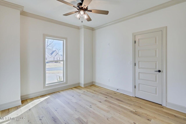 spare room featuring ceiling fan, ornamental molding, light wood-type flooring, and a wealth of natural light