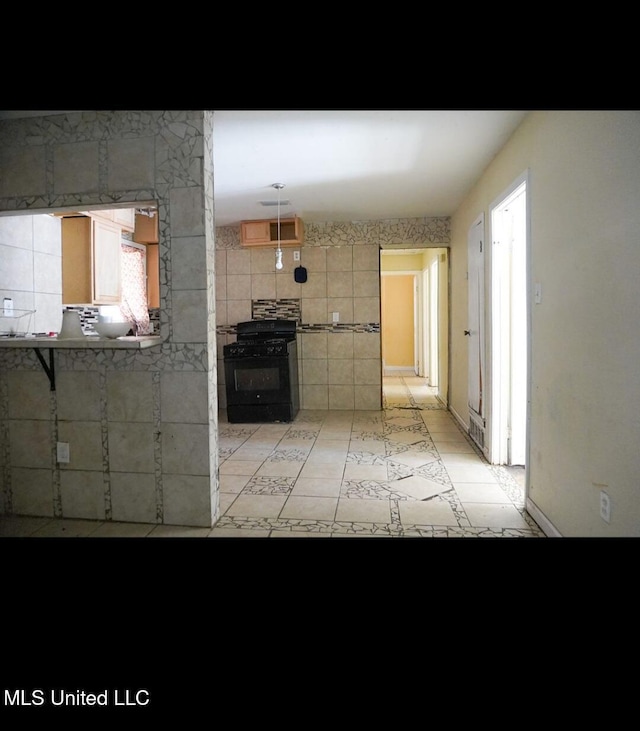 kitchen with black range with gas stovetop and light tile patterned flooring