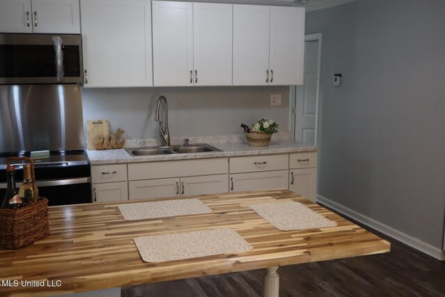 2411 14th St, Pascagoula, MS 39567 - kitchen featuring stainless steel microwave, a sink, wood counters, white cabinets, and wood finished floors
