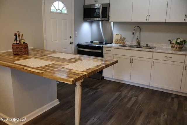 2411 14th St, Pascagoula, MS 39567 - kitchen with stainless steel microwave, wooden counters, a sink, dark wood finished floors, and white cabinets