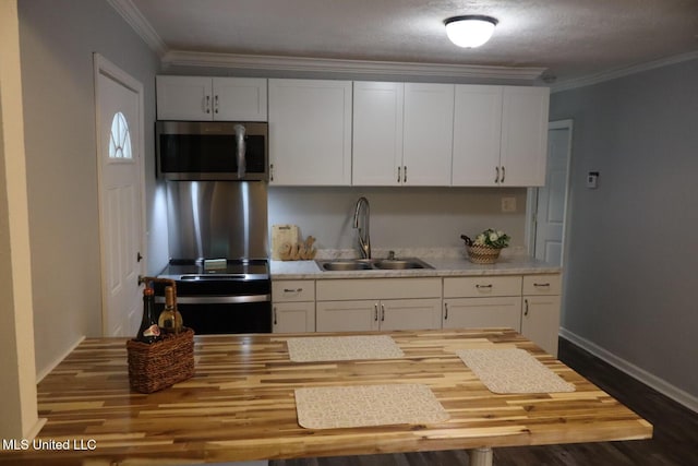 2411 14th St, Pascagoula, MS 39567 - kitchen with stainless steel microwave, a sink, white cabinetry, and ornamental molding