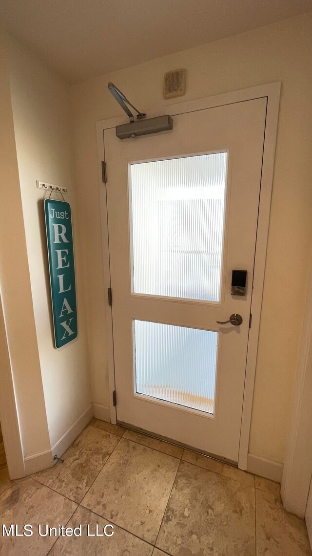 doorway with light tile patterned floors