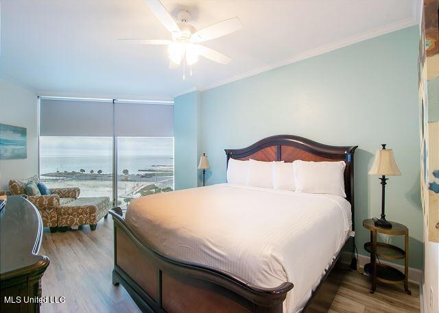 bedroom with ornamental molding, hardwood / wood-style floors, and ceiling fan