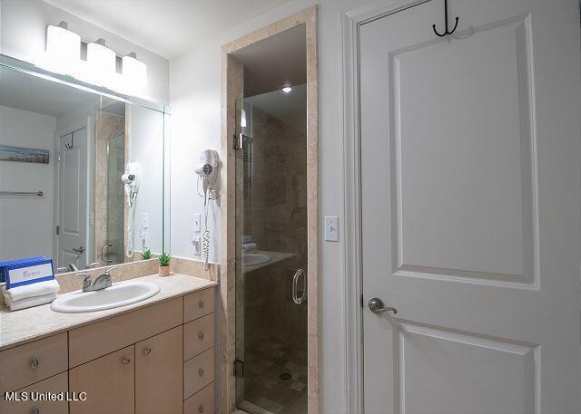 bathroom featuring a shower with door and vanity