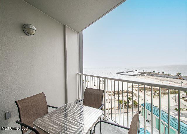 balcony featuring a water view and a view of the beach