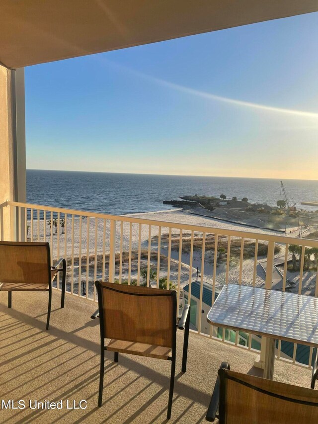 balcony featuring a water view and a beach view