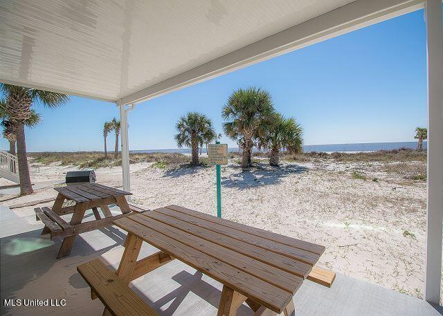 exterior space with a patio, a water view, and a beach view