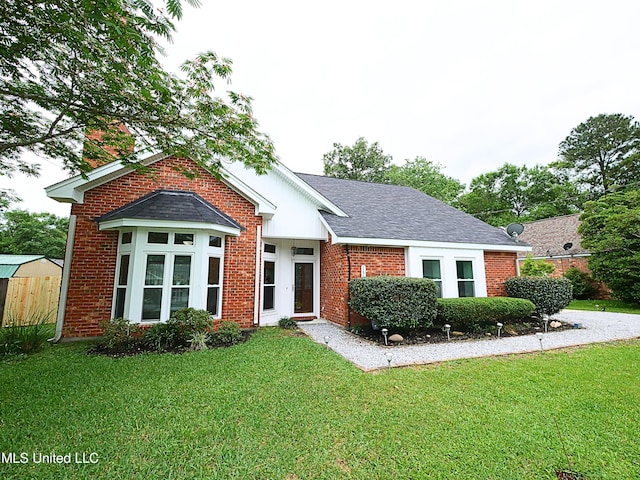 7869 Hilo Way, Diamondhead, MS 39525 - view of front of property featuring a front yard, brick siding, and a shingled roof