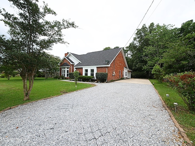 7869 Hilo Way, Diamondhead, MS 39525 - view of front of property with driveway, brick siding, a front yard, and a chimney