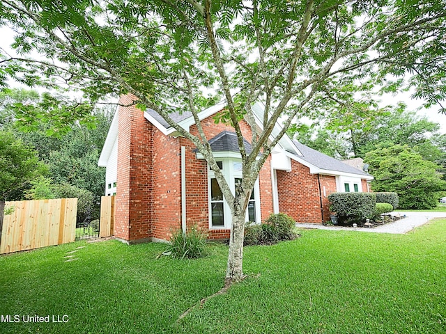 7869 Hilo Way, Diamondhead, MS 39525 - view of home's exterior featuring a chimney and brick siding