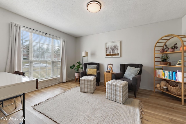 living area with hardwood / wood-style flooring and a textured ceiling