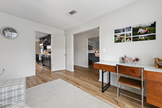 interior space with light wood-type flooring and a textured ceiling