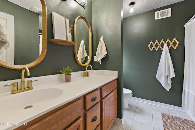 bathroom featuring tile patterned flooring, vanity, a textured ceiling, and toilet