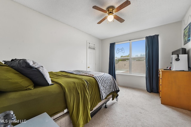 carpeted bedroom with ceiling fan and a textured ceiling