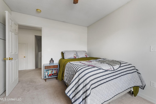 carpeted bedroom featuring a textured ceiling and ceiling fan