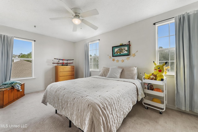 carpeted bedroom featuring multiple windows, ceiling fan, and a textured ceiling