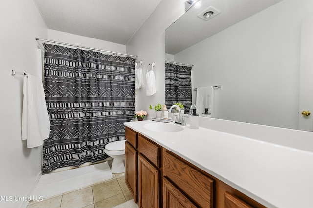 bathroom featuring tile patterned flooring, vanity, toilet, and a textured ceiling