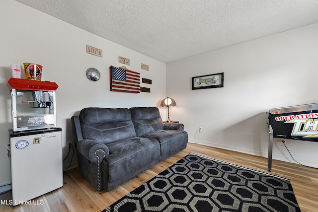 living room featuring wood-type flooring and a textured ceiling