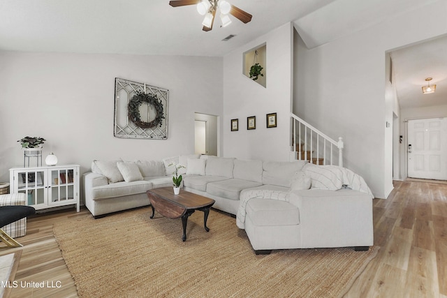 living room featuring wood-type flooring, ceiling fan, and lofted ceiling