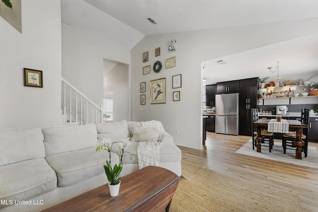 living room featuring light hardwood / wood-style flooring and vaulted ceiling