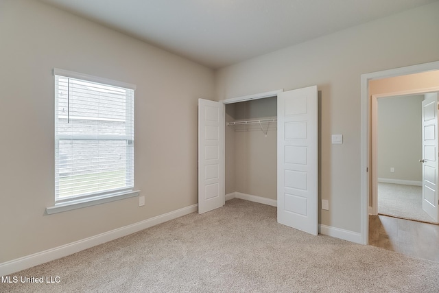 unfurnished bedroom featuring a closet and light colored carpet