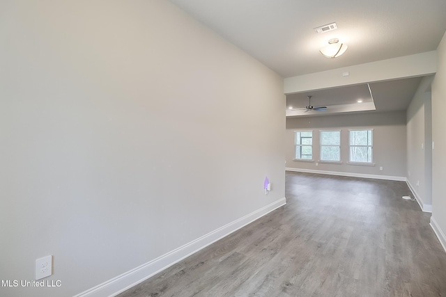 unfurnished room featuring light hardwood / wood-style flooring, ceiling fan, and a tray ceiling