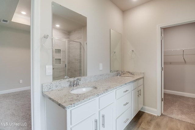 bathroom with vanity, hardwood / wood-style floors, and a shower with door