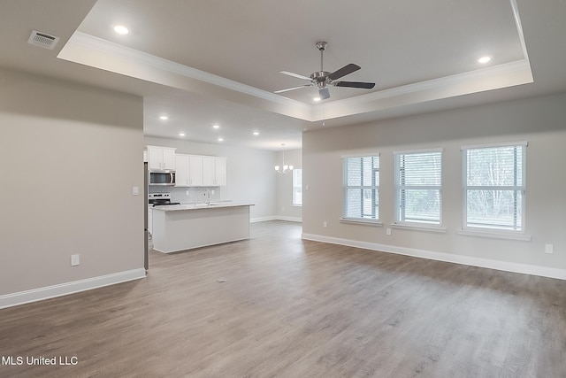 6253 Sandhill Cv, Ocean Springs, MS 39564 - unfurnished living room featuring a raised ceiling, ornamental molding, ceiling fan, light wood finished floors, and baseboards