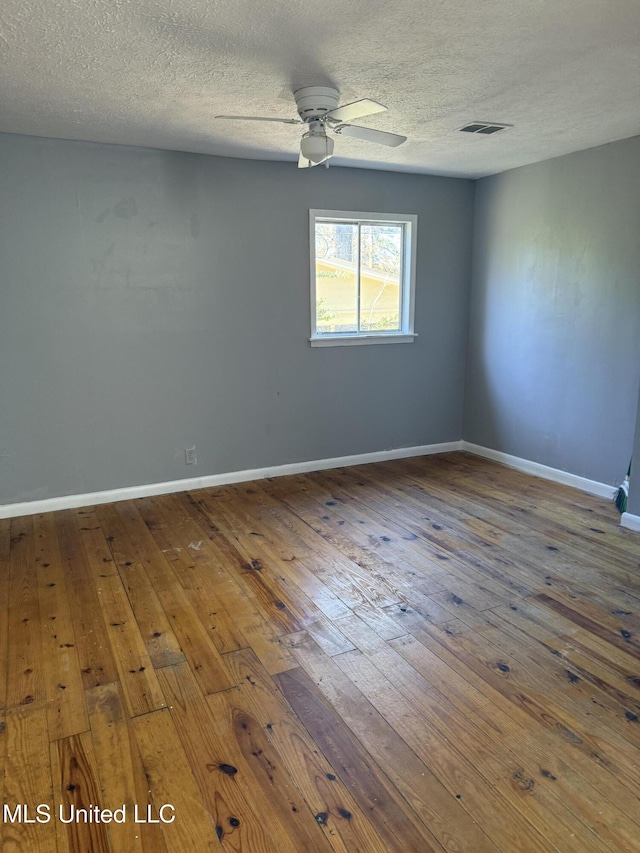 empty room with a textured ceiling, ceiling fan, and wood-type flooring