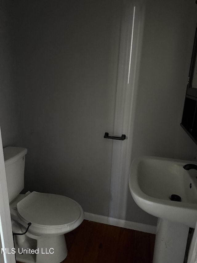 bathroom with toilet and hardwood / wood-style floors