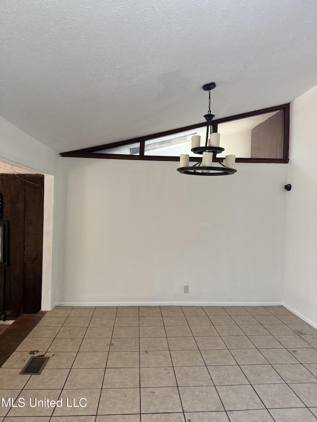 tiled spare room with lofted ceiling, a chandelier, and a textured ceiling